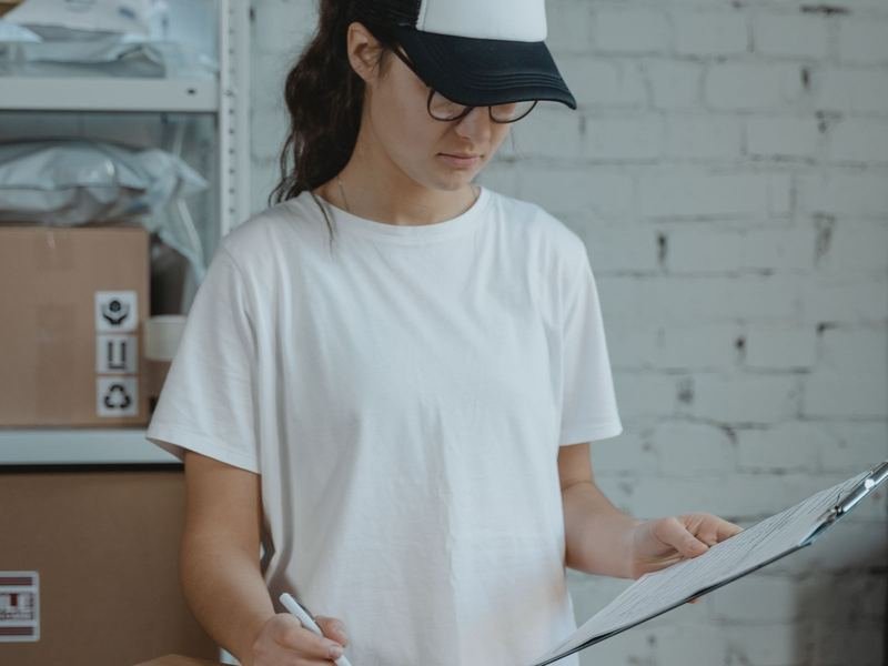 Team member checking a shipment against a clipboard in a stockroom